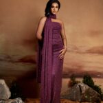 Woman wearing KAIA, a dark plum strapless diamante glitter mesh column gown with floor-length scarf by XELENE.