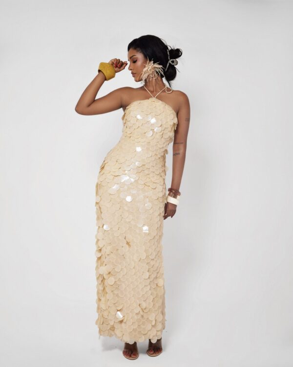 Woman wearing Solea, a butter yellow floor-length hand-stitched 3D paillette sequin halter dress by XELENE.